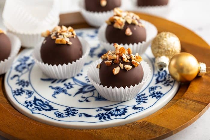 Three turtle cookie balls on a blue and white plate