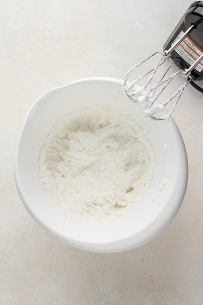 Shortening and sugar creamed together in a white mixing bowl.