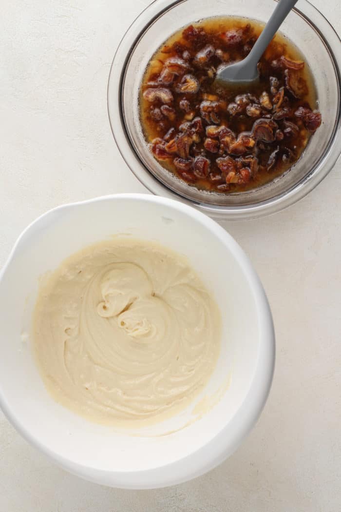 Shortening, sugar, and egg mixture for cake in a white mixing bowl next to a bowl of soaked dates.