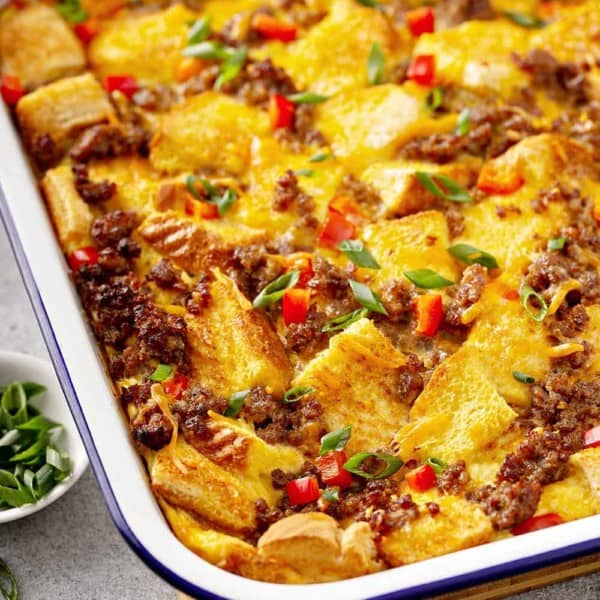 Close-up of overnight breakfast casserole in a white baking dish on a gray countertop