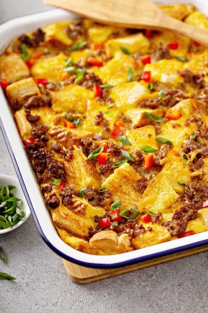 Close-up of overnight breakfast casserole in a white baking dish on a gray countertop