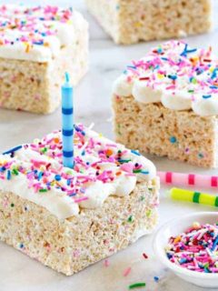 Birthday Marshmallow Cereal Treats are topped with buttercream frosting and loaded with sprinkles.