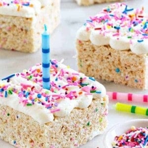 Birthday Marshmallow Cereal Treats are topped with buttercream frosting and loaded with sprinkles.