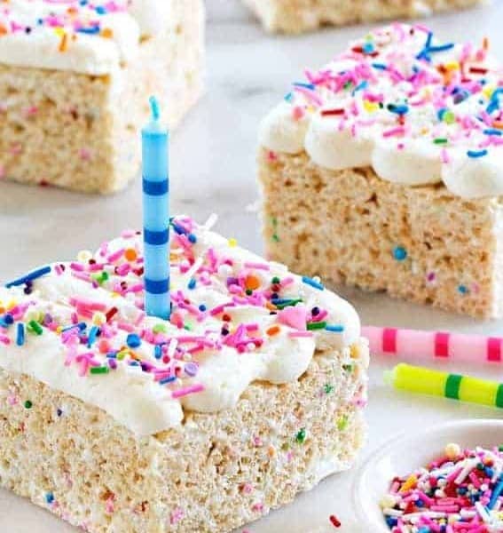Birthday Marshmallow Cereal Treats are topped with buttercream frosting and loaded with sprinkles.