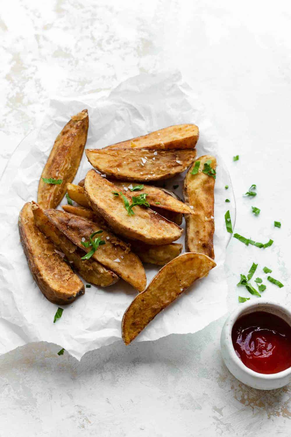 Jo Jo Potato Wedges served garnished with herbs alongside a ramekin of ketchup