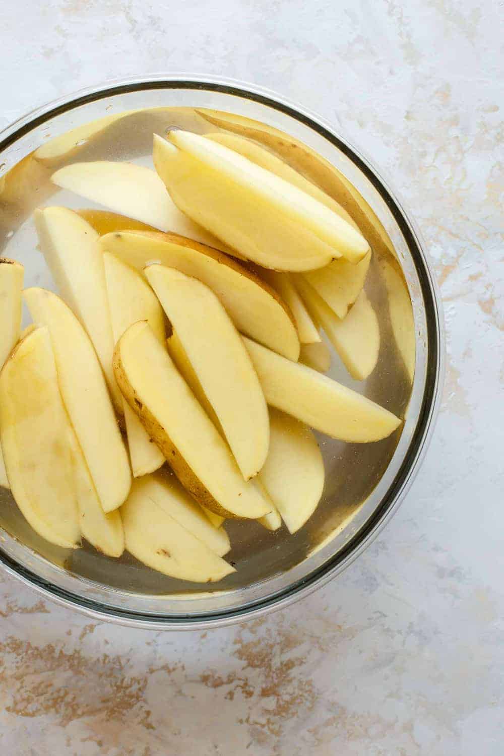 Cut potato wedges soaking in water