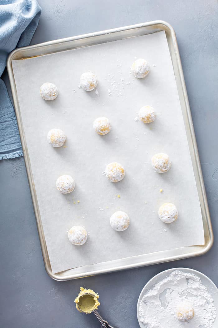 Balls of gooey butter cookie dough on a baking sheet, ready to bake