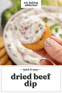 Hand holding up a cracker dipped in dried beef dip. Text overlay includes recipe name.