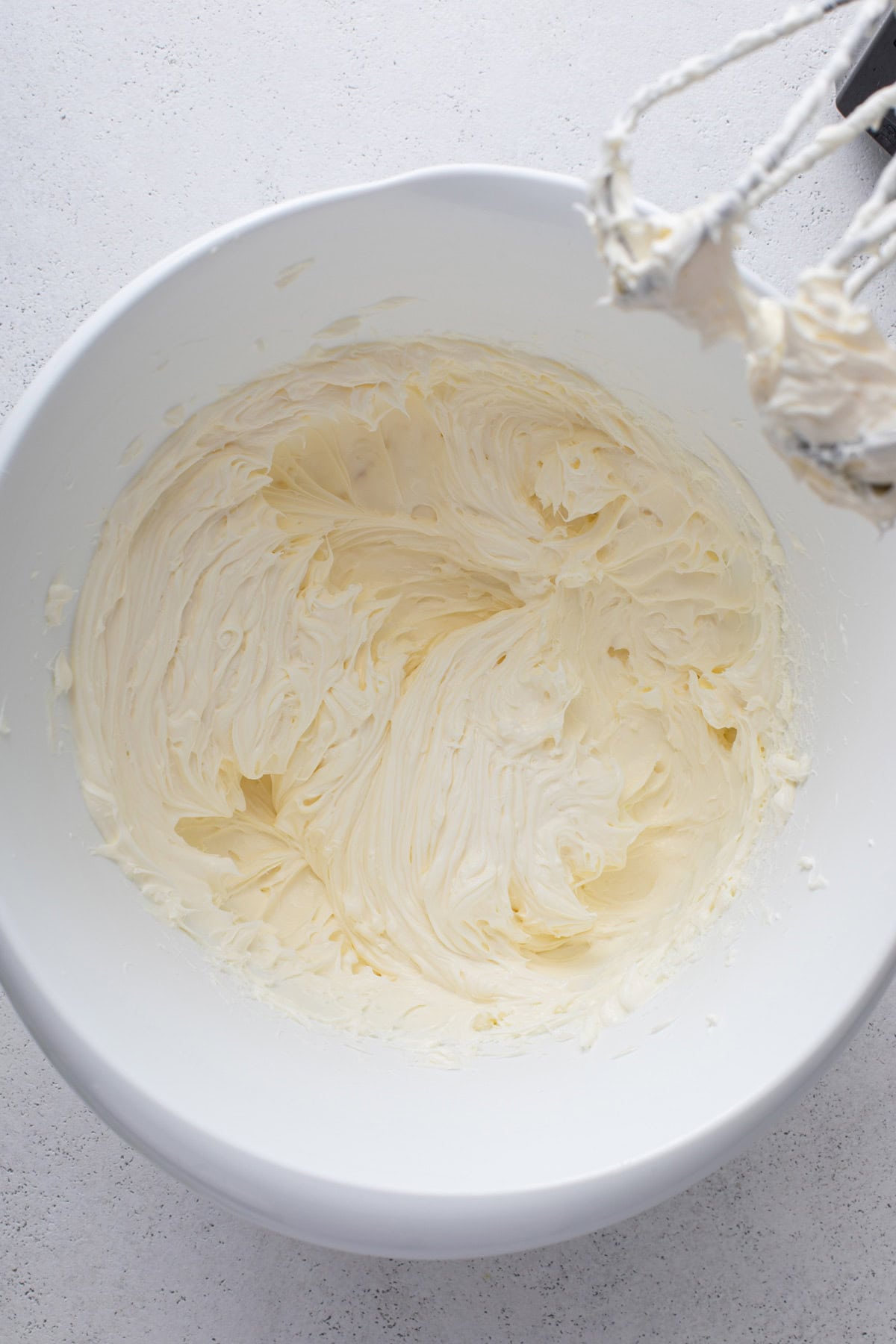 Cream cheese beaten in a white bowl.