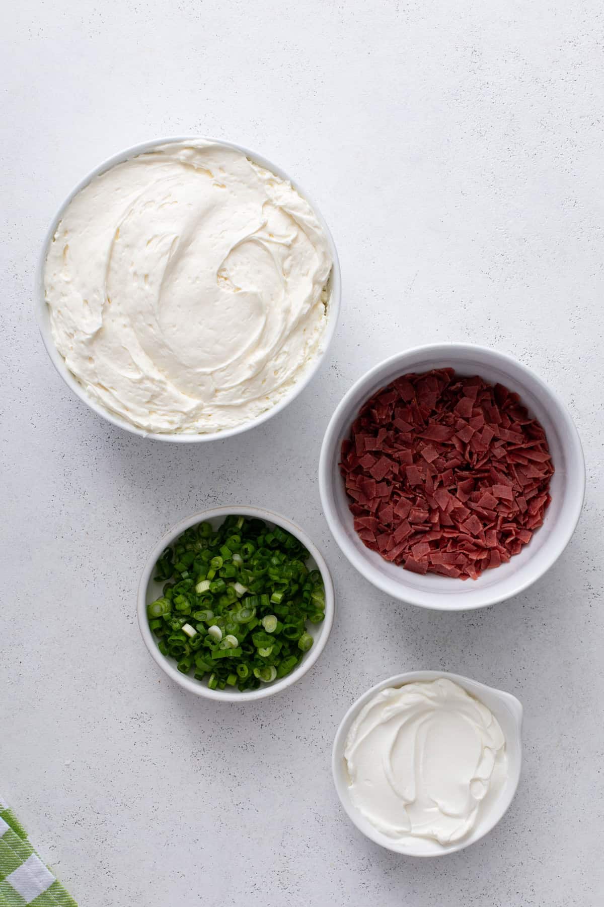 Ingredients for dried beef dip arranged on a countertop.