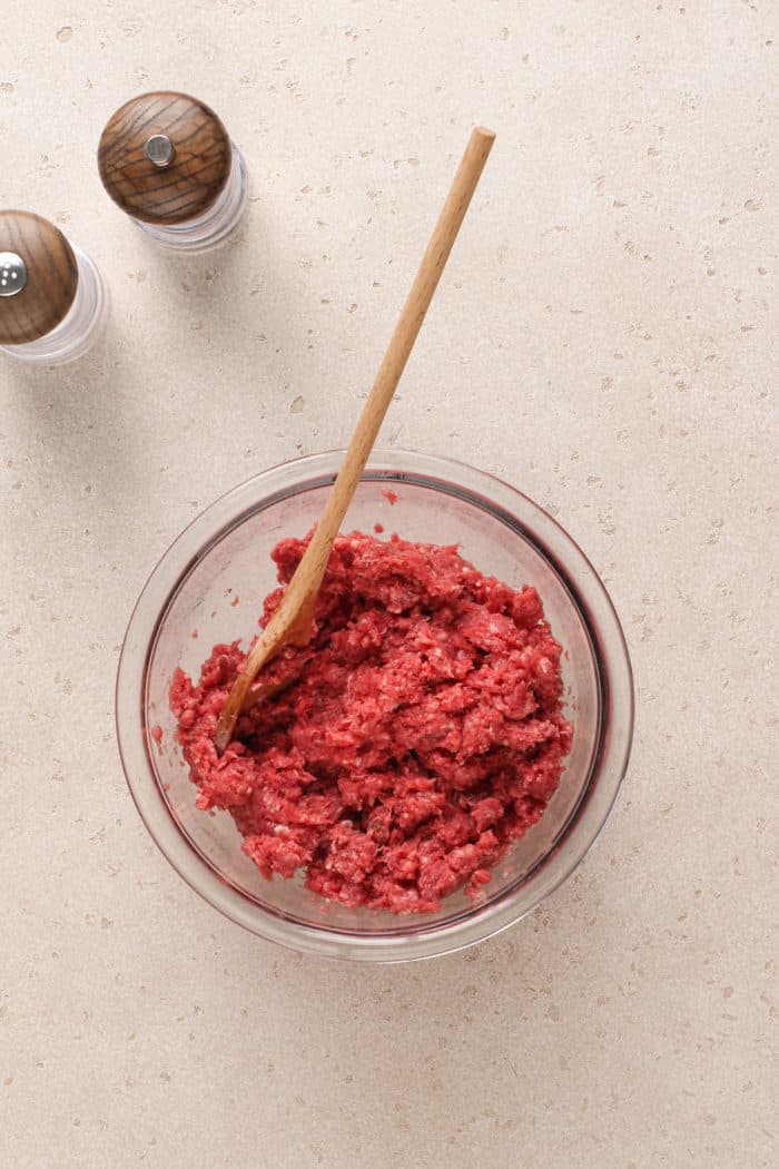 Ground beef for sloppy joes in a glass mixing bowl.