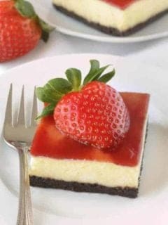 Strawberry white chocolate cheesecake bars have a chocolate cookie-like crust and strawberry jam topping. These are so good! Recipe contains a gluten-free option.