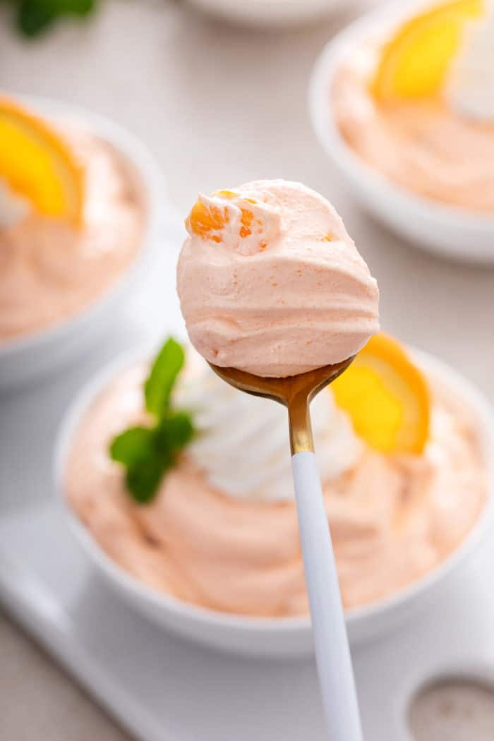 Spoonful of orange fluff being held up to the camera.