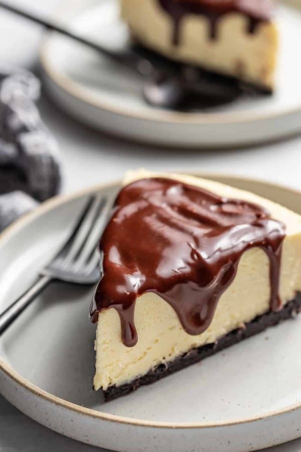 Slice of Baileys cheesecake next to a fork on a gray plate