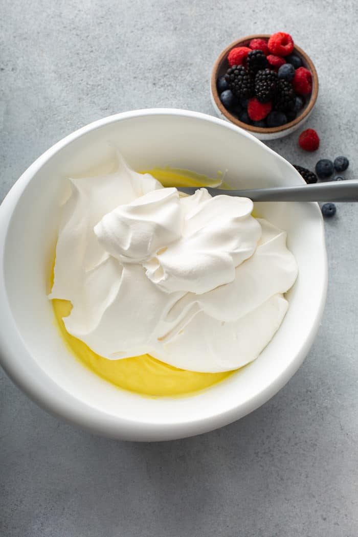 Frozen whipped topping being folded into lemon pudding for icebox cake