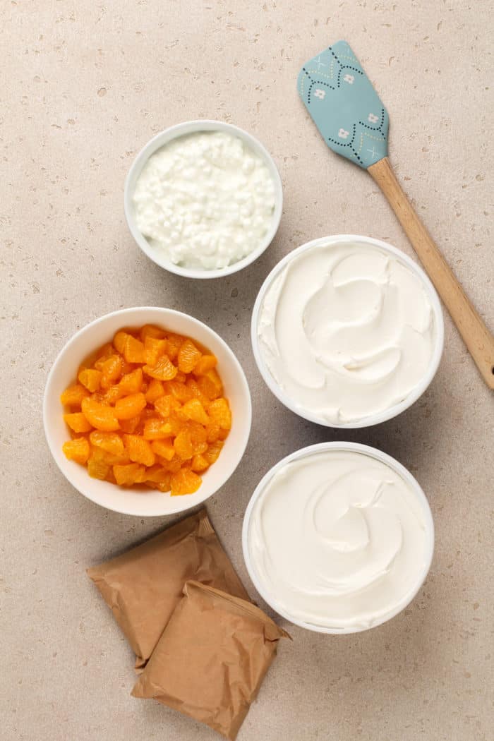 Ingredients for orange fluff arranged on a beige countertop.