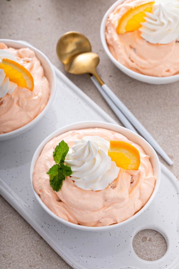 White bowl filled with orange fluff set on a white tray.