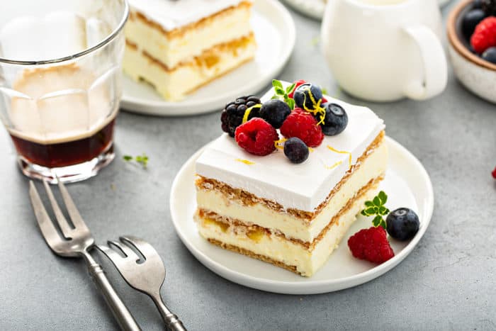 Slice of lemon icebox cake garnished with fresh berries on a white plate