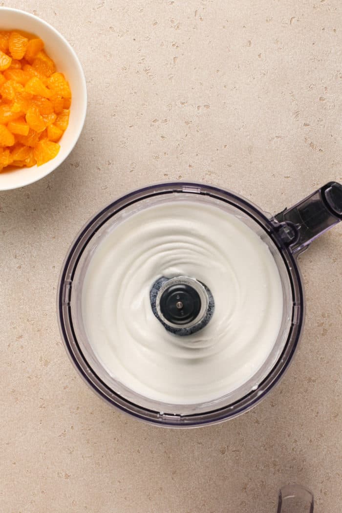 Pureed cottage cheese in the bowl of a food processor.