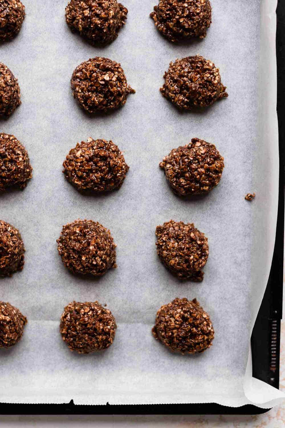 Scooped no bake cookies on a parchment-lined sheet pan