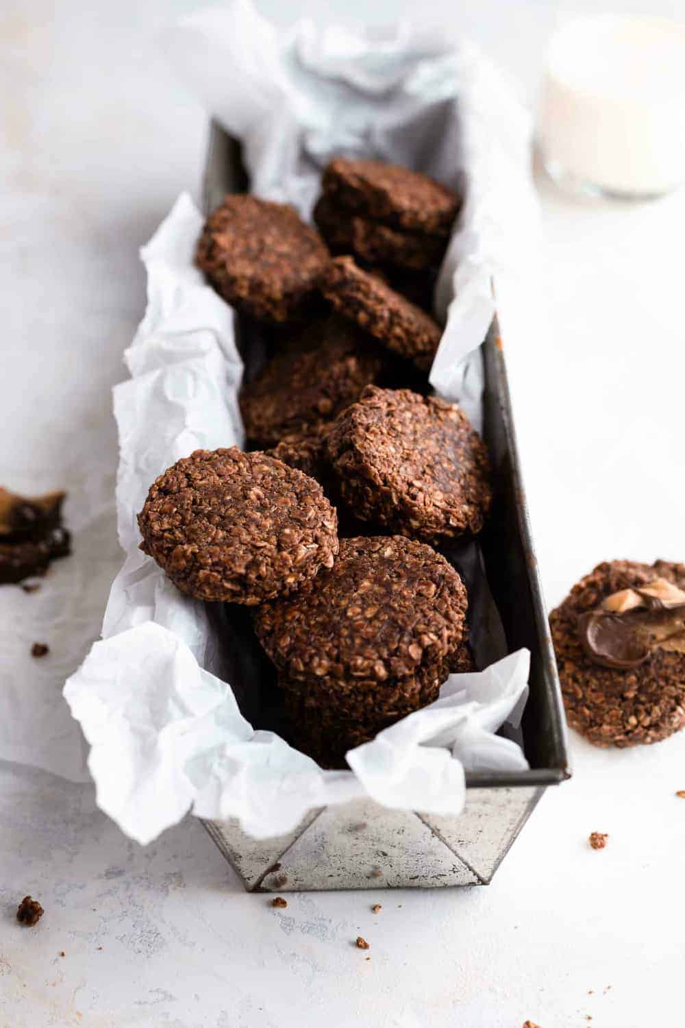 Chocolate no bake cookies in a parchment-lined loaf pan on a white surface