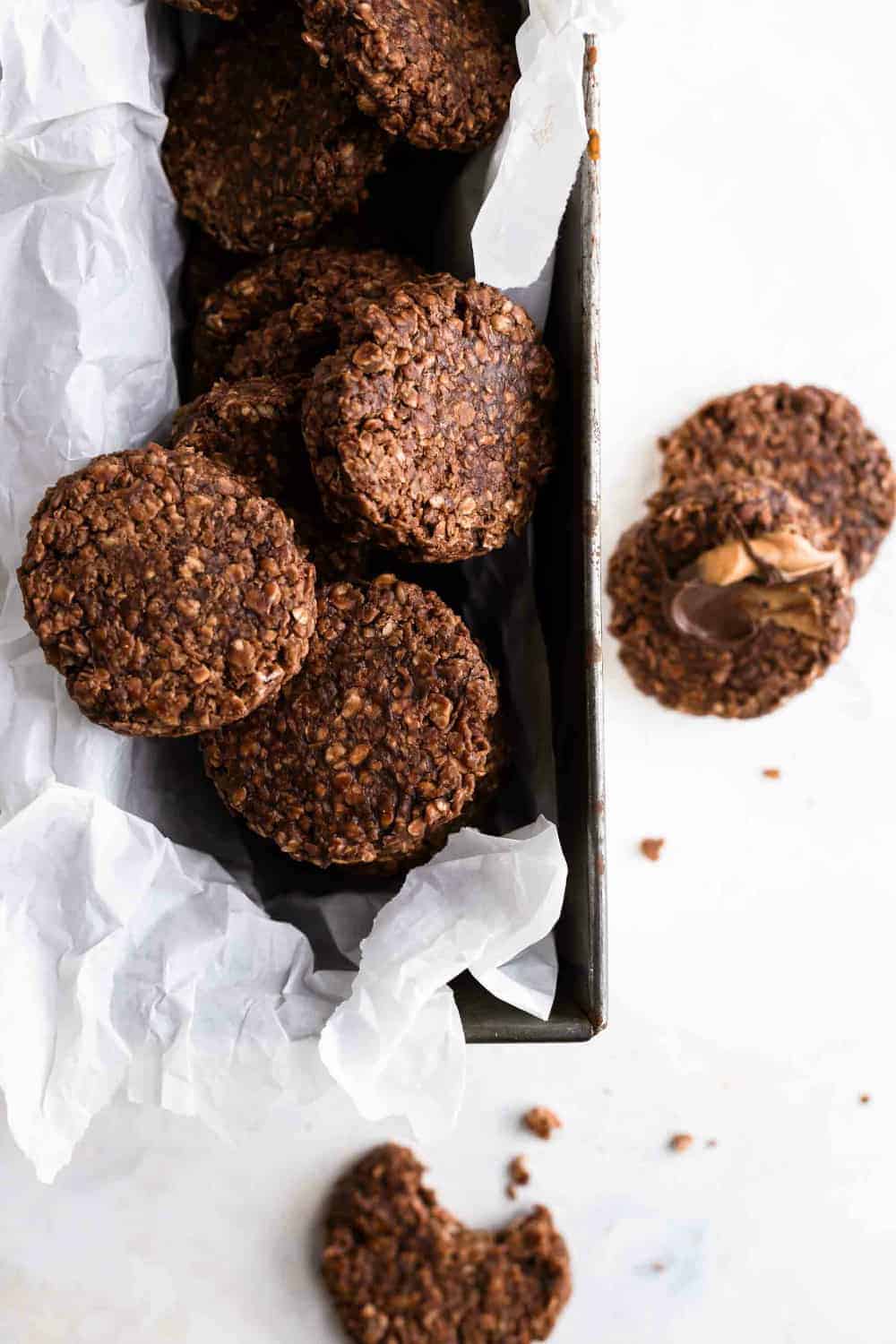 Overhead view of chocolate, peanut butter and oat no bake cookies piled in a parchment-lined loaf pan