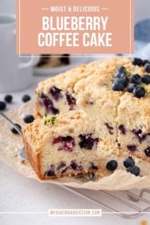 Plated slices of blueberry coffee cake on a countertop next to coffee creamer and a bowl of blueberries. Text overlay includes recipe name.
