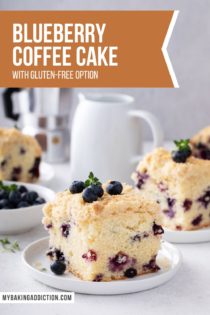 Plated slices of blueberry coffee cake on a countertop next to coffee creamer and a bowl of blueberries. Text overlay includes recipe name.