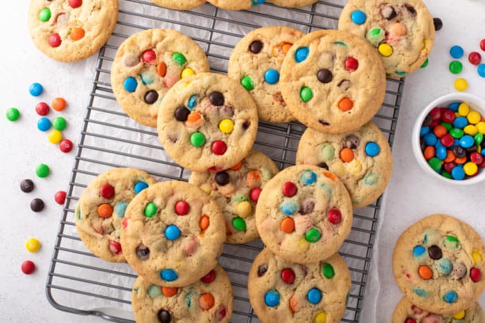 M&M cookies arranged on a wire cooling rack to cool.