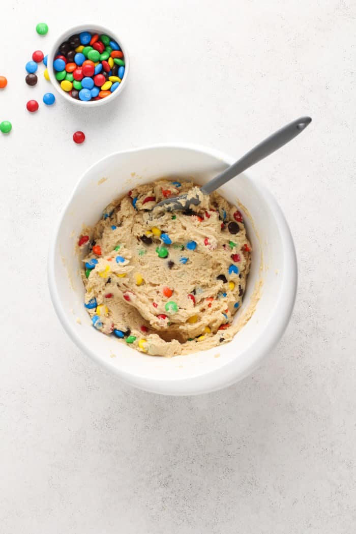 M&M cookie dough in a white mixing bowl.