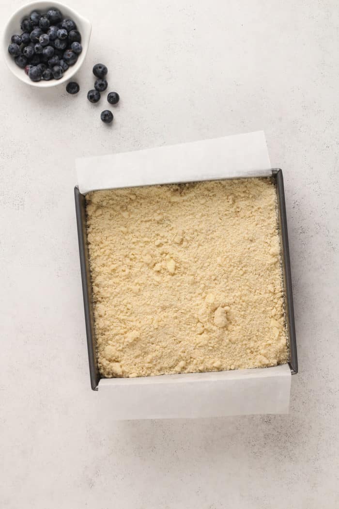 Unbaked blueberry coffee cake in a cake pan, ready to go in the oven.