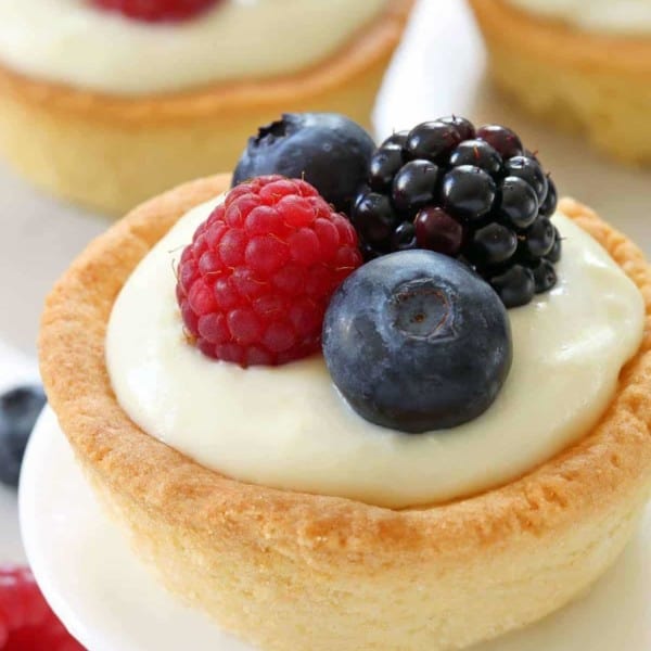 Berry Cookie Cups have a sugar cookie crust and white chocolate cream cheese filling! Top them with fresh berries for the perfect summer dessert. Recipe contains gluten-free option.