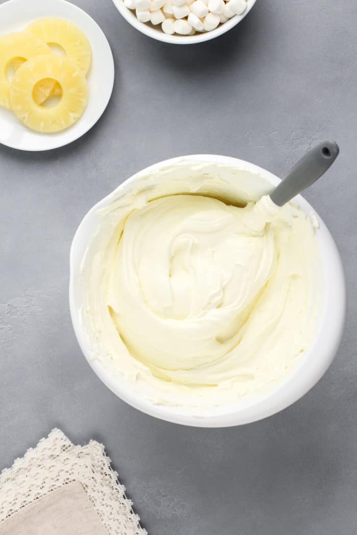 Base for pineapple fluff folded together in a white mixing bowl.