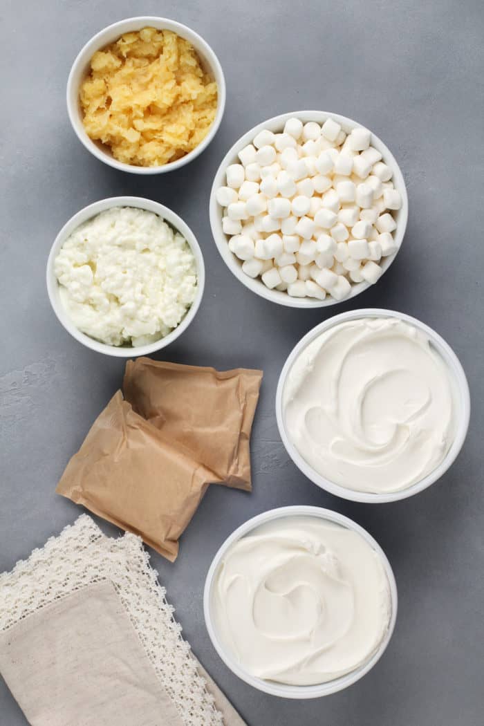 Ingredients for pineapple fluff arranged on a gray countertop.