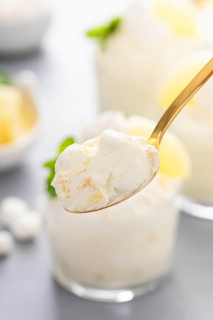 Spoon holding up a bite of pineapple fluff to the camera.