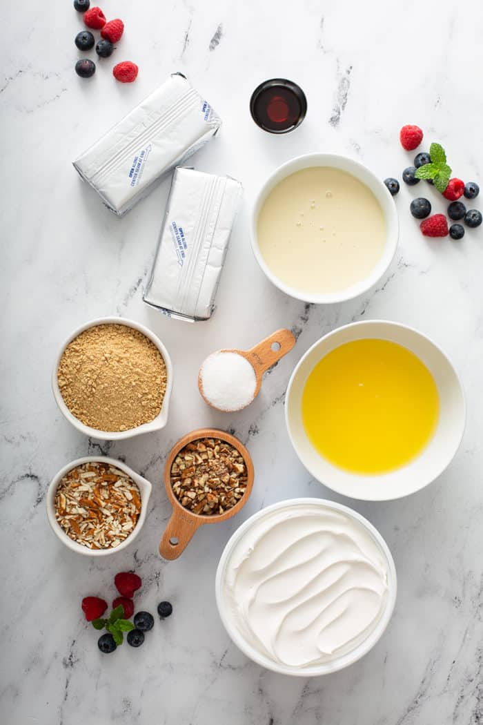 Ingredients for no-bake frozen cheesecake arranged on a marble countertop