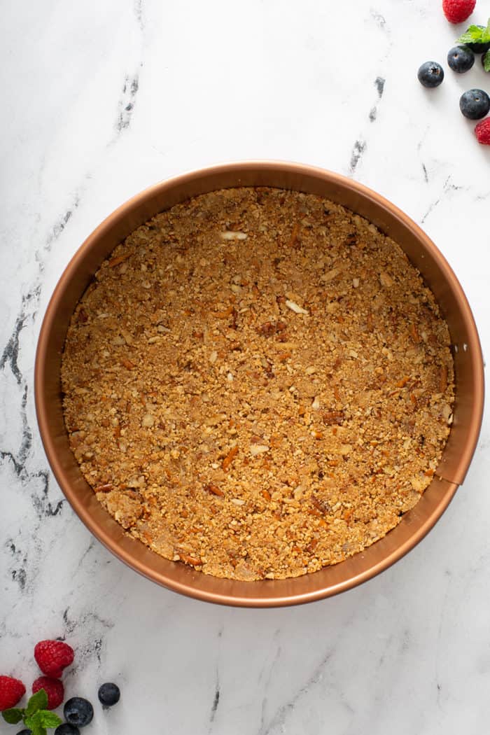 Assembled crust for frozen cheesecake pressed into the bottom of a springform pan