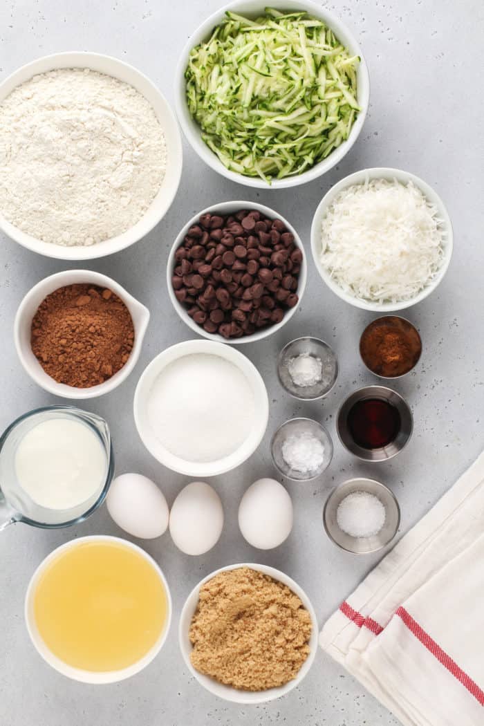 Chocolate zucchini bread ingredients arranged on a gray countertop.