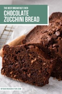 Loaf of chocolate zucchini bread on a piece of parchment paper. A slice has been cut from the end of the loaf. Text overlay includes recipe name.