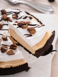 Pie server lifting up a slice of peanut butter pie from the full pie.