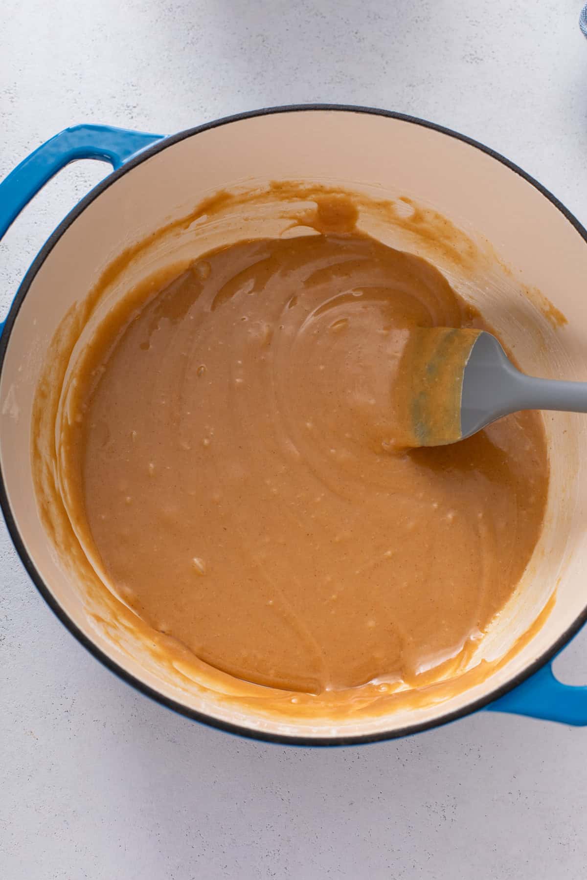 Peanut butter melted into hot corn syrup and sugar in a large saucepan.