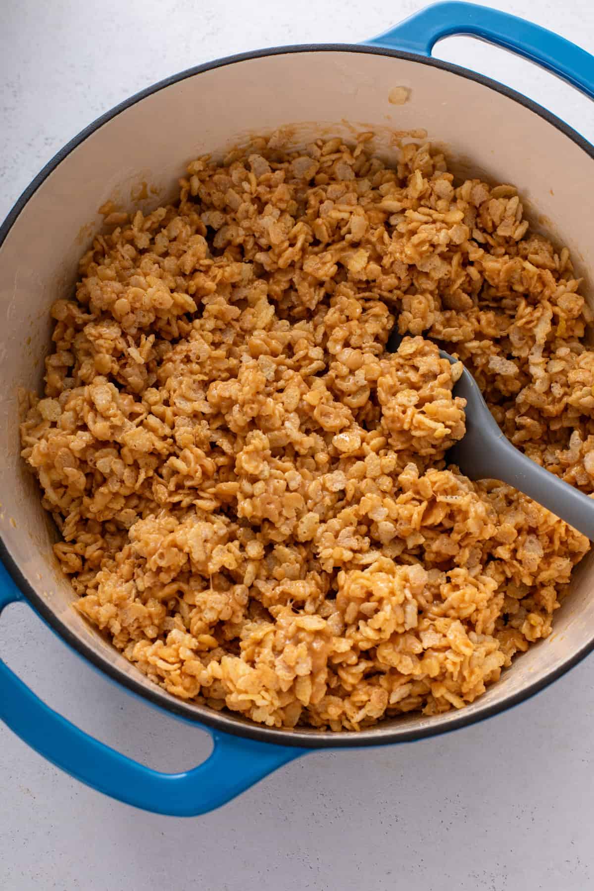 Rice krispies cereal mixed into a peanut butter mixture for scotcheroos.