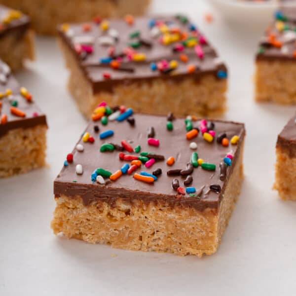 Sliced scotcheroo topped with rainbow sprinkles on a countertop.