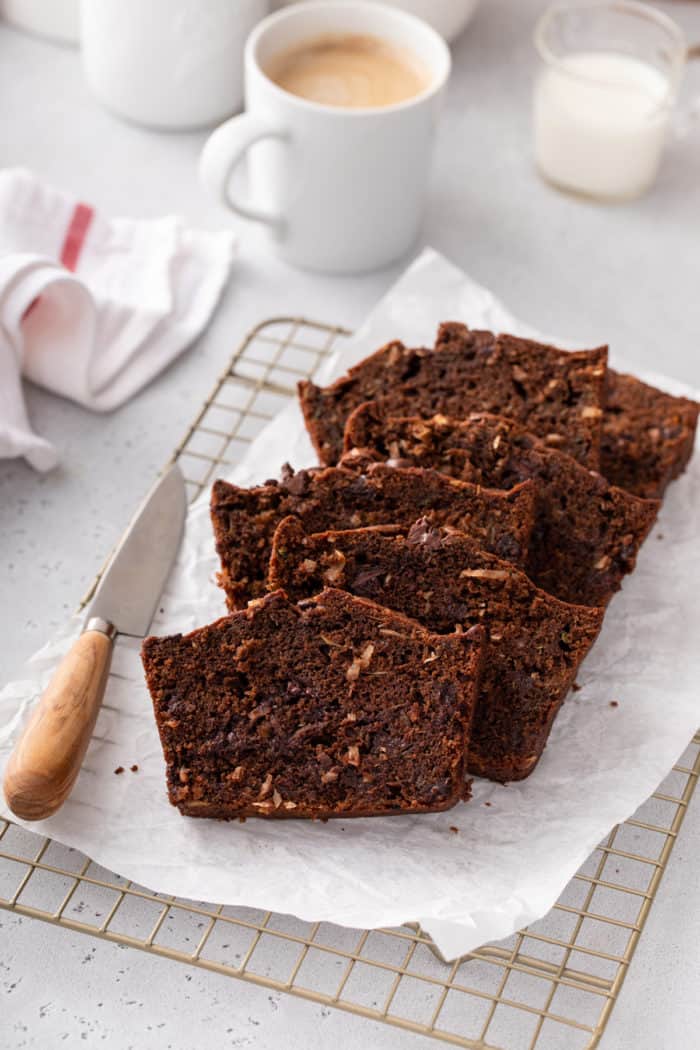 Sliced loaf of chocolate zucchini bread on a piece of parchment paper.