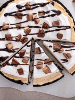 Sliced peanut butter pie topped with chocolate sauce and peanut butter cups.