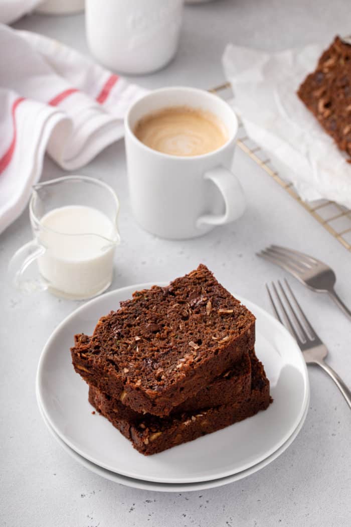 Two slices of chocolate zucchini bread stacked on a white plate.