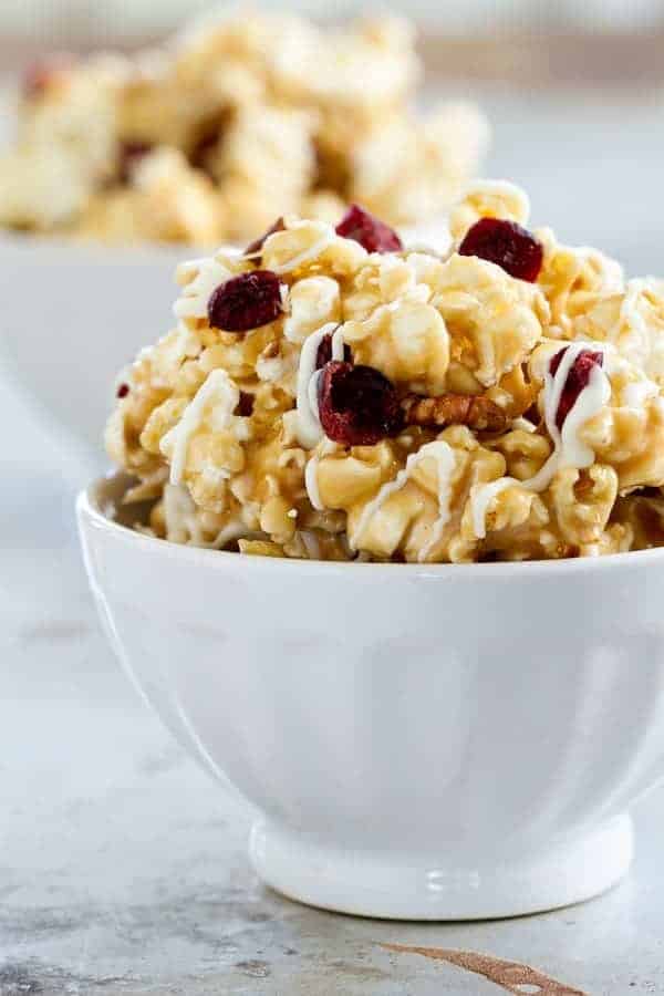 Maple Caramel Corn with marshmallows, chopped pecans, dried cranberries, and a decadent drizzle of white chocolate. THIS is the caramel corn you'll want to make and eat, all fall long.