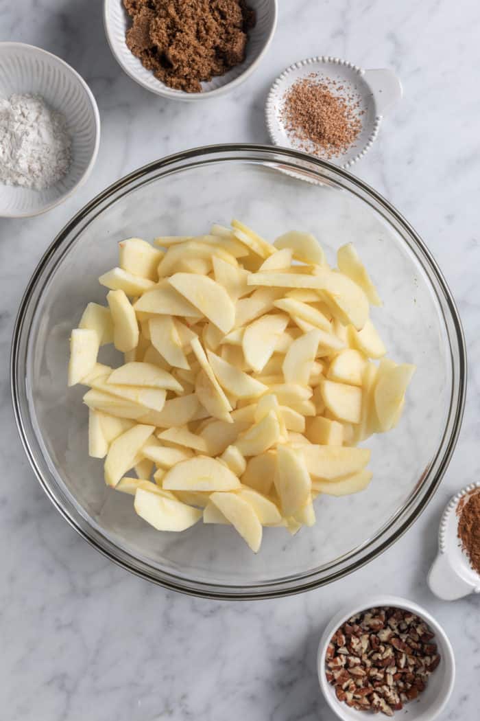 Apple galette filling ingredients on a marble countertop.