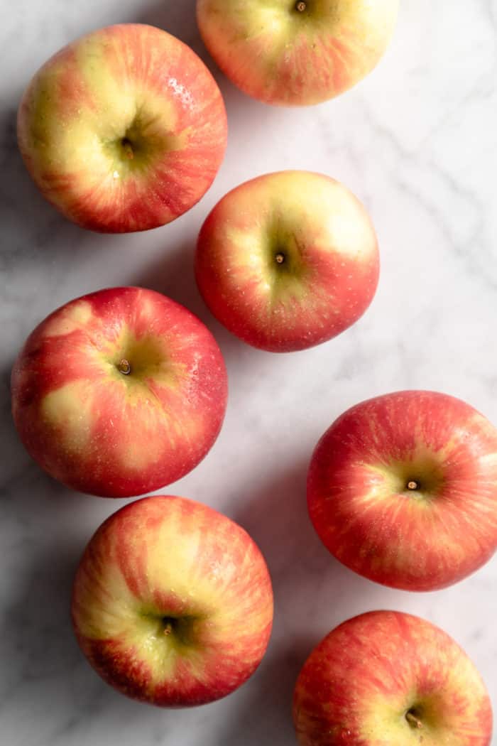 Several apples scattered on a marble surface.