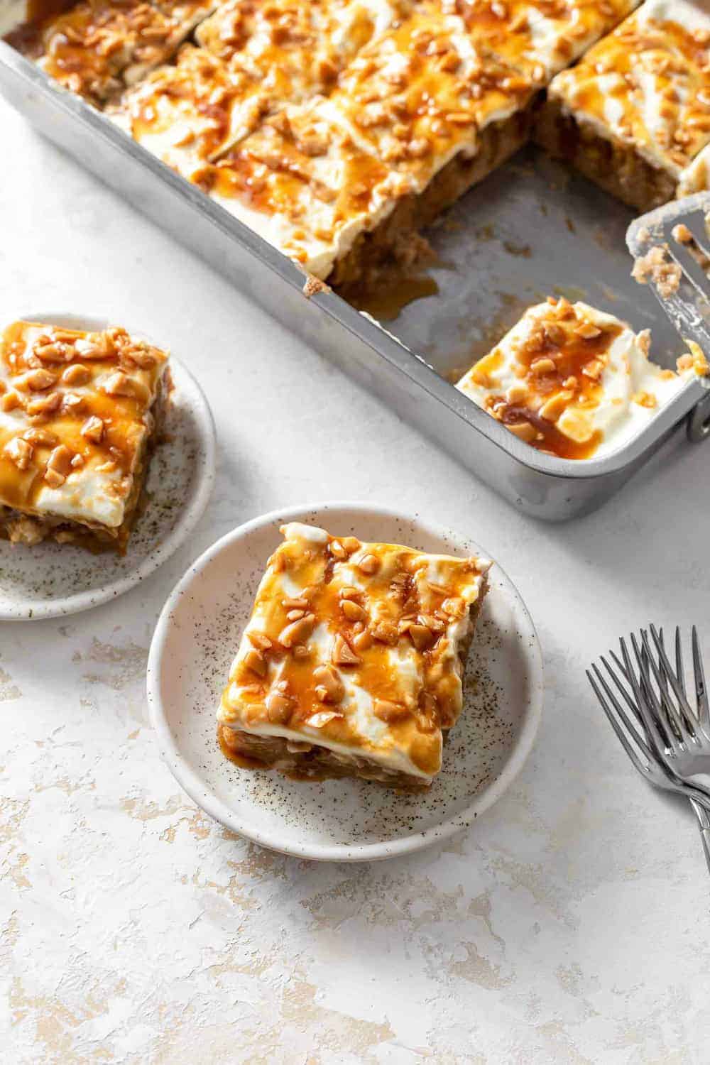 Sliced caramel apple poke cake, with two slices on plates